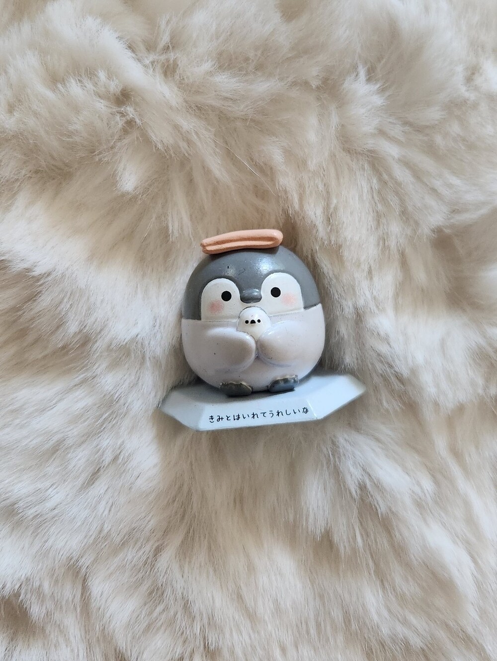 Cute baby penguin figure holding a small bird